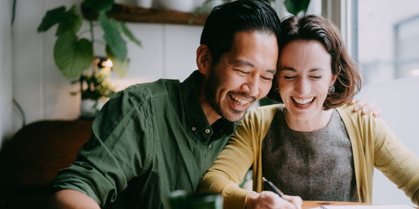 A smiling couple reviewing documents together at home, evoking collaboration and family-focused assessment outcomes.